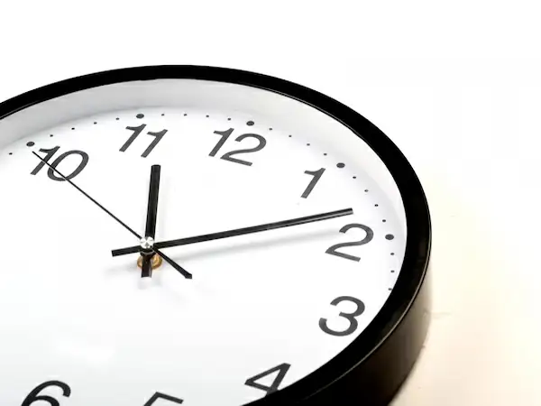 Foto de um relógio e os ponteiros marcando 12 horas
