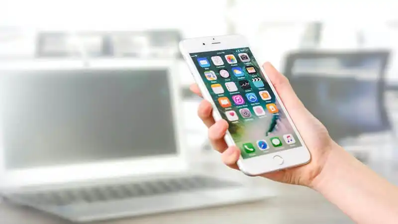 The image shows a person holding a smartphone