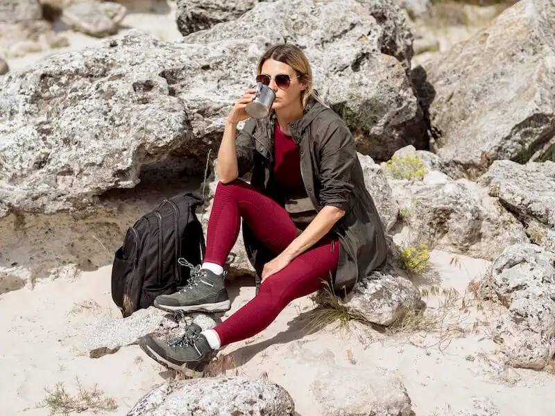 How to take product photos - in-context shots The image shows a womand drinking water sitting on a rock.