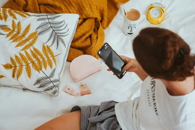 The image shows a woman using a smartphone
