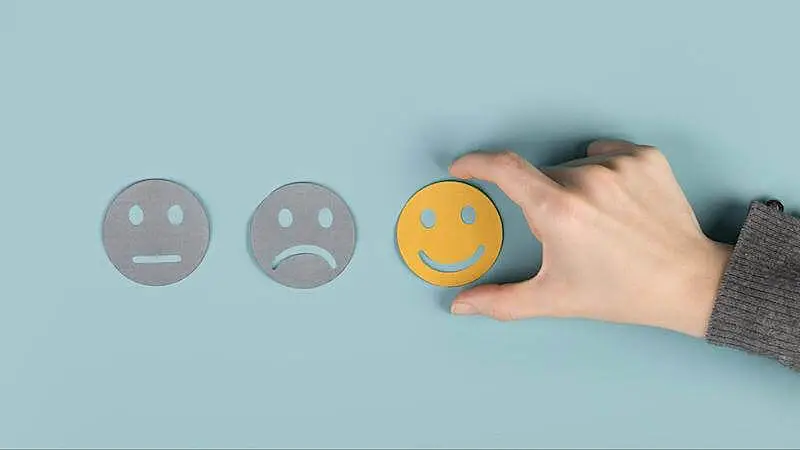 The image shows three face icons: a neutral face, a sad face, and a happy one.
