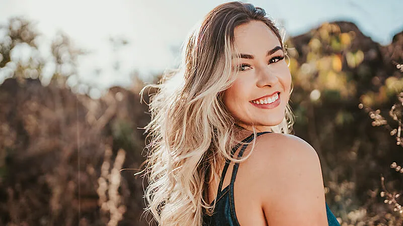 Foto de uma menina de vestido branco olhando sobre o ombro