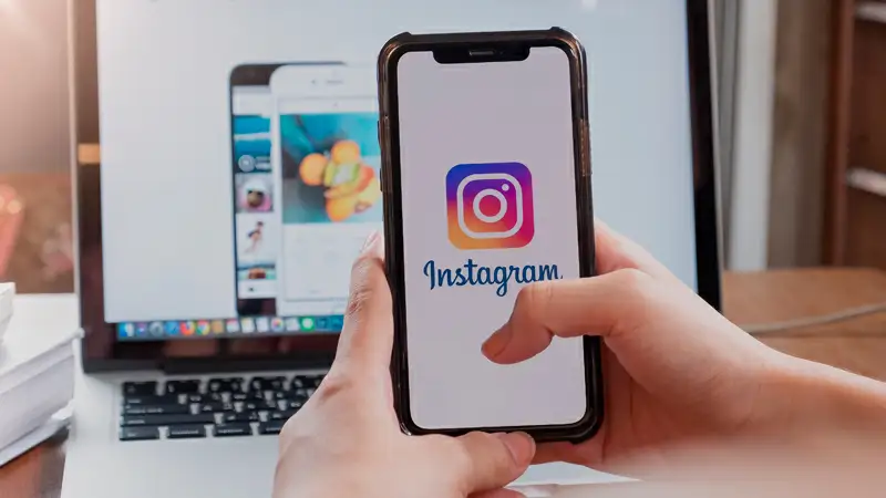 Foto de uma pessoa usando um notebook e abrindo o Instagram pelo navegador