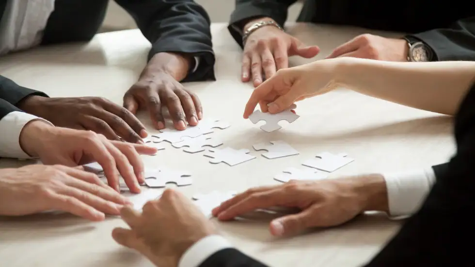 Liderazgo Foto de un grupo manejando un rompecabezas