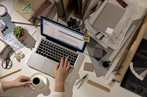 pessoa utilizando o notebook enquanto toma café