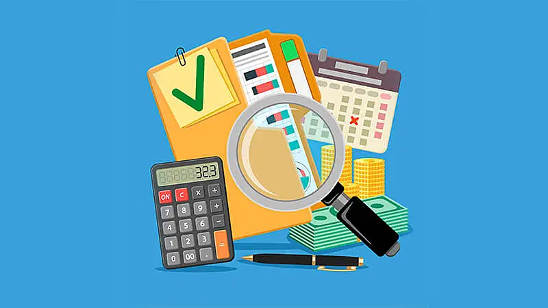 Imagem de um notebook, várias notas e moedas e uma calculadora