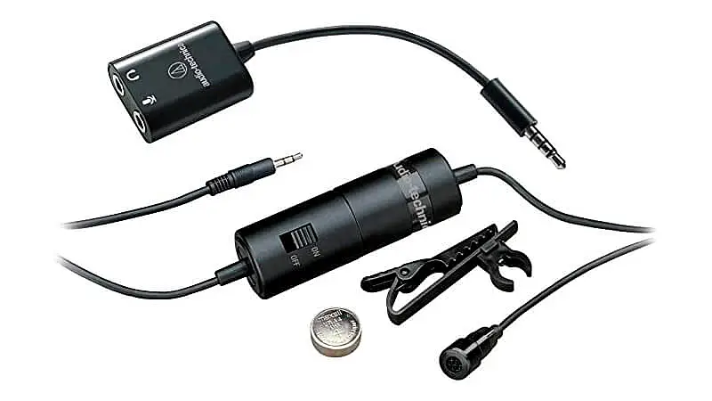 imagem de um microfone de lapela Audio Technica ao lado de um adaptador p2, um clipe de lapela e uma bateria