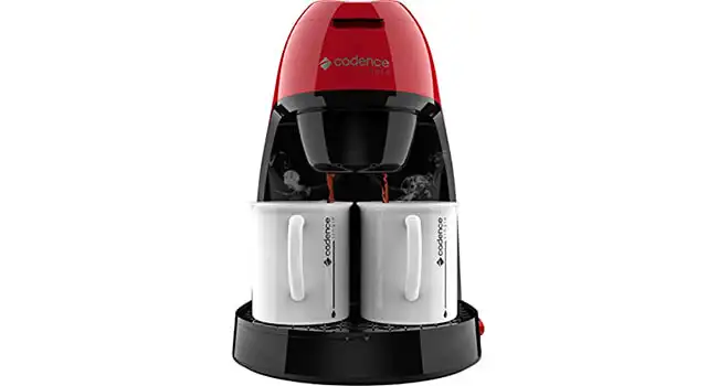 foto de uma mini cafeteira Single da Cadence na cor vermelha servindo duas xícaras de café brancas