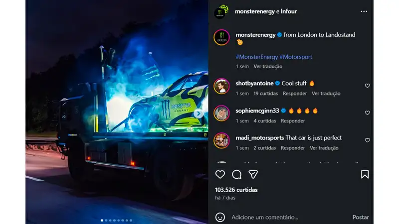 Postagem em carrossel do carro de corrida da equipe Monster Energy em exibição durante evento de motorsport, com iluminação azul e destaque para a marca Monster Energy.