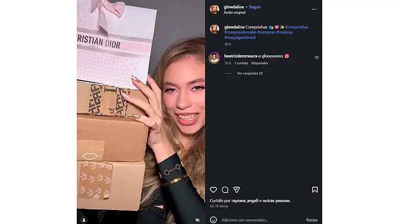 Captura de tela de um post de unboxing no Instagram onde uma jovem mulher sorridente segura várias caixas de presente, incluindo uma com a marca Christian Dior, em um ambiente bem iluminado. Ela transmite alegria ao mostrar as embalagens de compras de beleza e moda.