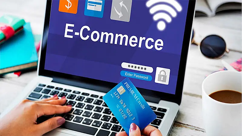 The image shows a laptop screen where it's written "e-commerce".