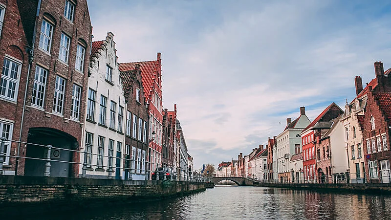 Foto panorâmica de uma cidade na bélgica com casas ao lado de um rio