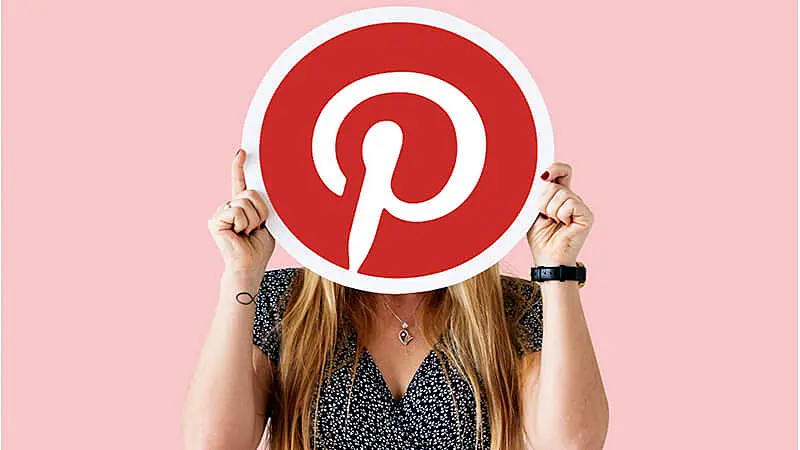 Foto de uma mulher segurando a logo do Pinterest