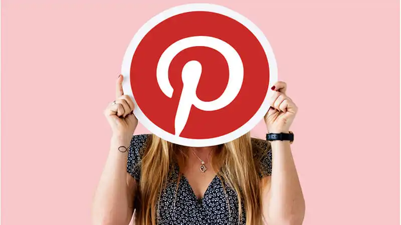 Foto de uma mulher segurando a logo do Pinterest