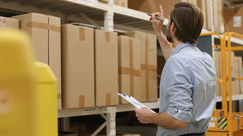 Homem segurando um tablet em um estoque
