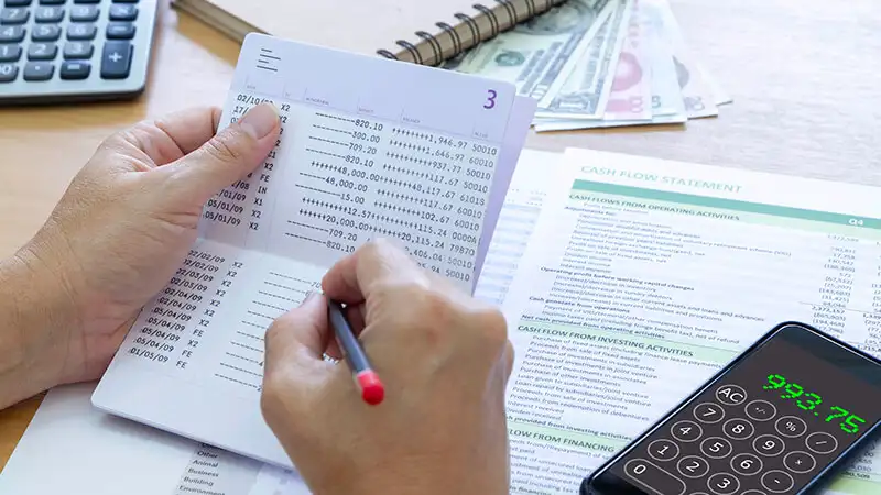 Uma pessoa anotando e usando uma calculadora