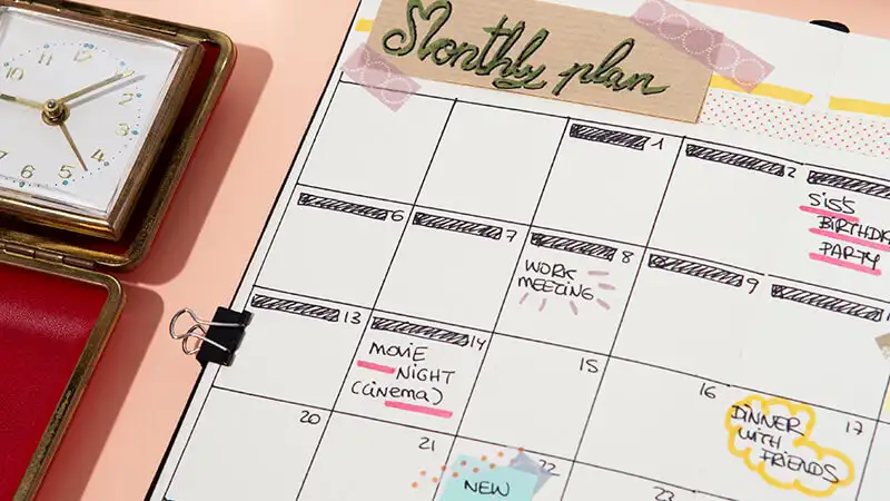 Foto de uma pessoa preenchendo um planner colorido