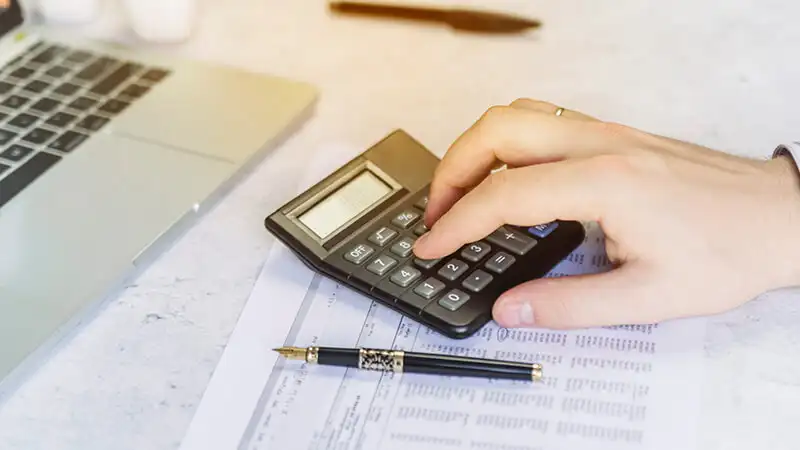 planilha fluxo de caixa Uma pessoa usando notebook e uma calculadora