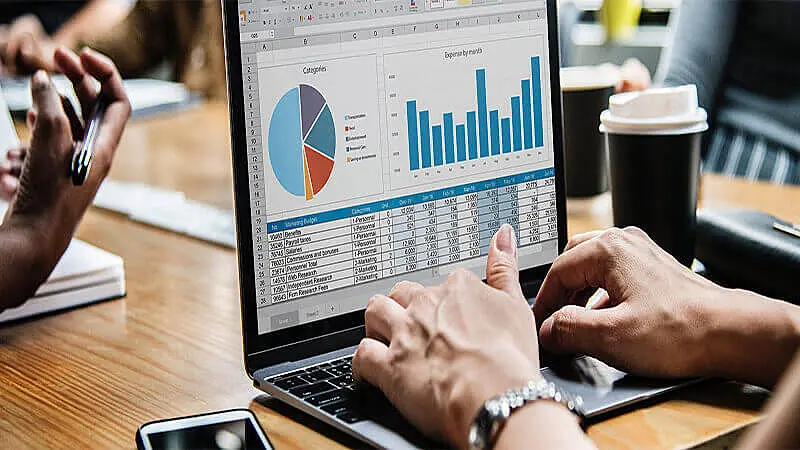 Pessoa preenchendo uma planilha no computador