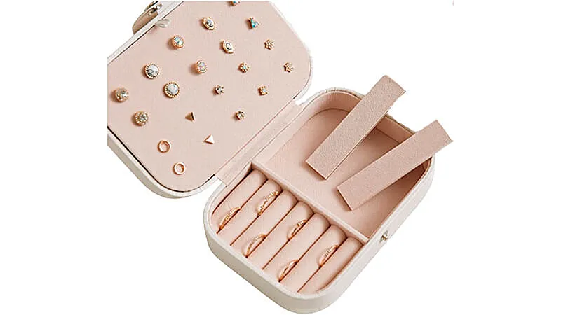 imagem de um mini porta joias na rosa com diversos brincos e anéis armazenados