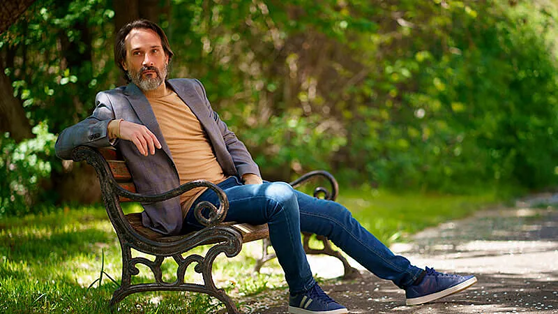 Foto de um jovem sentado em cima de um banco