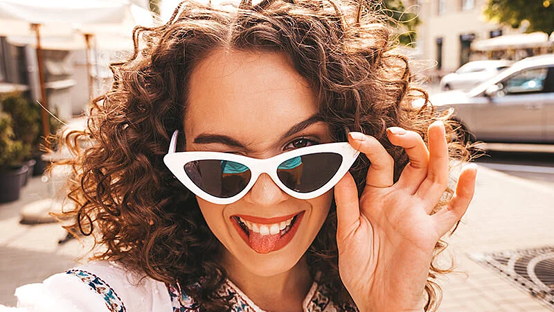 Foto de uma mulher olhando por cima do óculos