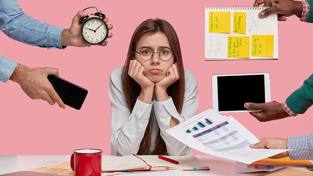 Foto de una empleada desmotivada recibiendo tareas y plazos