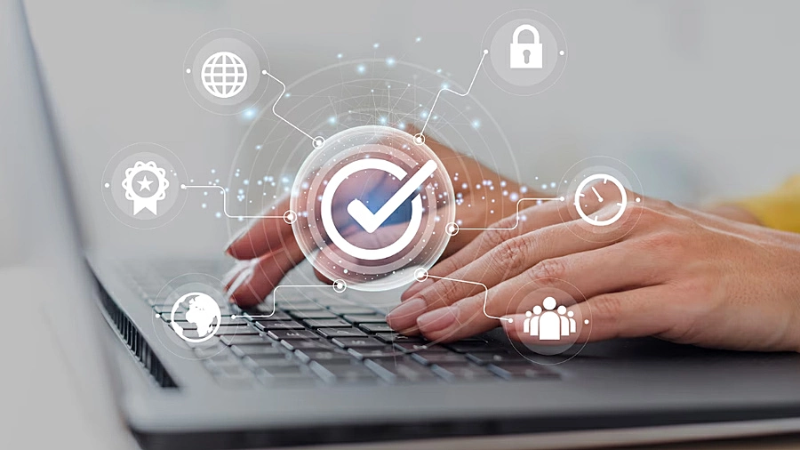 Foto de una persona usando no ordenador portátil y símbolos vectorizados sobre seguridad digital