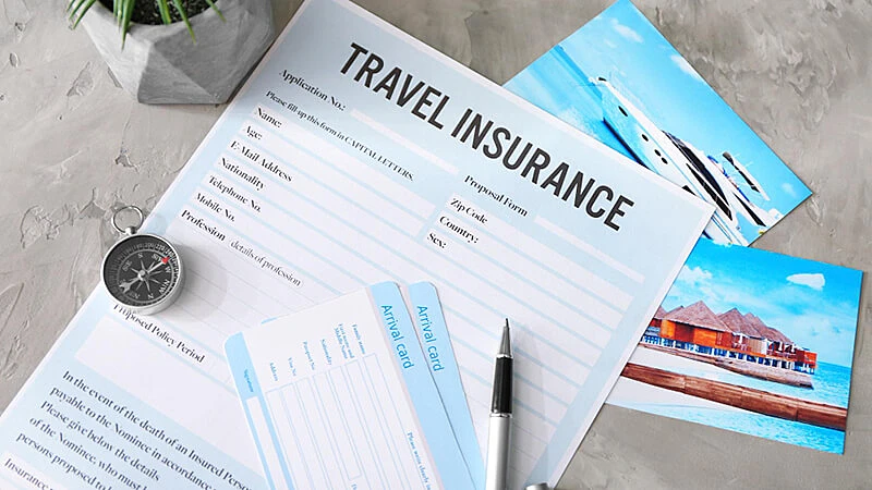 Foto de um contrato de seguro viagem, dois passaportes e um avião em miniatura em cima de uma mesa