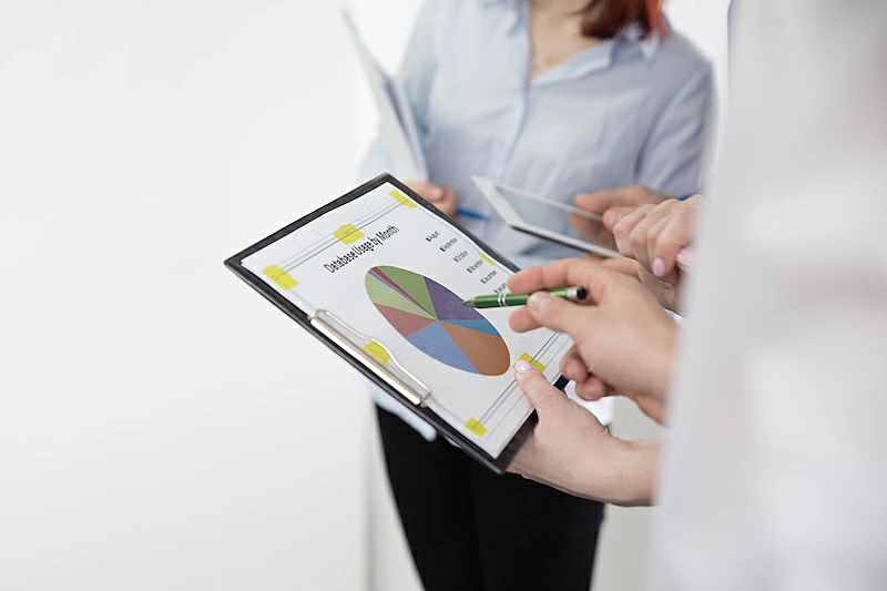 The image shows a person looking a chart on a tablet