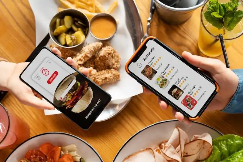 The image shows 2 people holding smartphones showing food delivery apps