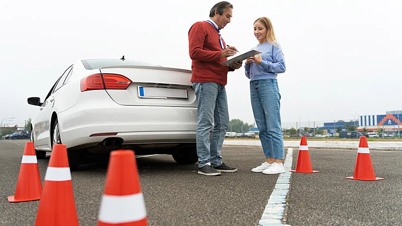 Mão segurando a chave de um carro e sua primeira habilitação