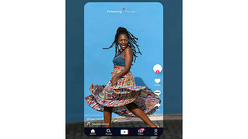 Foto de uma pessoa utilizando um celular e a logo do TikTok no fundo