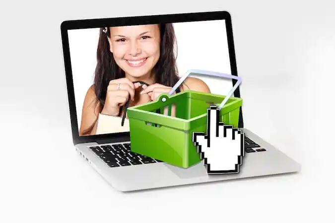 The image shows a laptop with a girl holdinf a shopping bag in the laptop screen. 