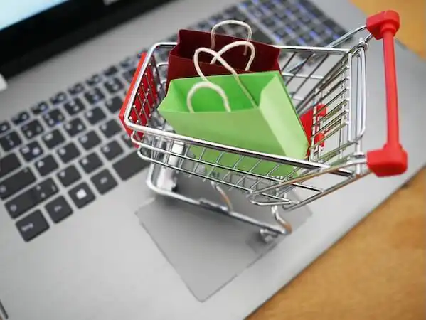 The image shows a shopping cart on a laptop keyboard